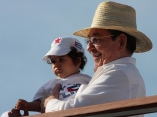 Raúl Castro carga a una niña durante el desfile por el 1ro de mayo en 2009. Foto: Ismael Francisco/ Cubadebate.