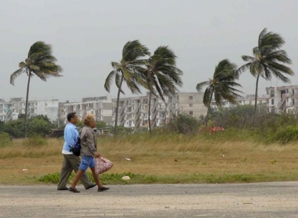 Dos personas caminan mientras la lluvia y el viento asociados al primer frente frío de la temporada invernal que llego al occidente de Cuba el 18 de octubre de 2009 golpean la vegetación en La Habana del Este. AIN FOTO/Roberto MOREJON RODRIGUEZ 