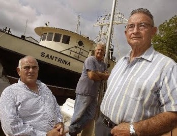 De izquierda a derecha, los terroristas Santiago Alvarez, Osvaldo Mitat y José Hilario Pujol junto al barco Santrina, que introdujo de manera ileagal a Posada Carriles en los Estados Unidos, en el 2005. (Roberto Koltun/ El Nuevo Herald).
