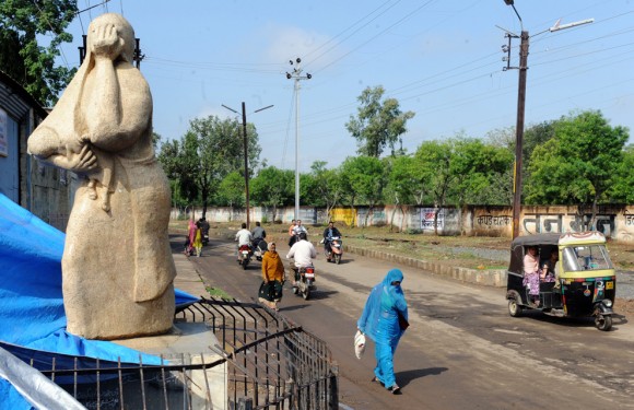 La gente camina junto a una estatua de una mujer con un niño muerto en sus brazos en Bhopal, India, el 18 de noviembre de 2009. (RAVEENDRAN / AFP / Getty Images)