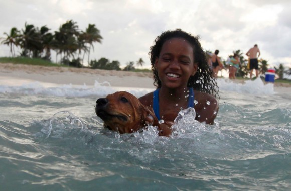 Una niña juega con su perro en la playa, el 4 de octubre de 2009. (REUTERS/Desmond Boylan)