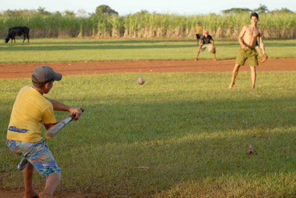 Muchachos jugando pelota de placer o maniguera, en Yaguajay, Sancti Spíritus, Cuba.