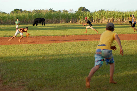 Muchachos jugando pelota de placer o maniguera, en Yaguajay, Sancti Spíritus, Cuba.