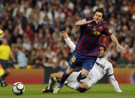 El argentino del Barcelona, Lionel Messi (I) y el jugador del Real Madrid, Raul Albiol (D), el 10 de abril de 2010