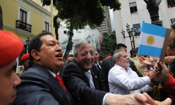 El presidente venezolano, Hugo Chávez, junto al secretario general de Unasur, Néstor Kirchner, y el presidente brasileño, Luiz Inácio Lula da Silva, saludan al pueblo venezolano, en la Plaza Bolívar en Caracas, el 6 de agosto de 2010. AIN FOTO/TELAM
