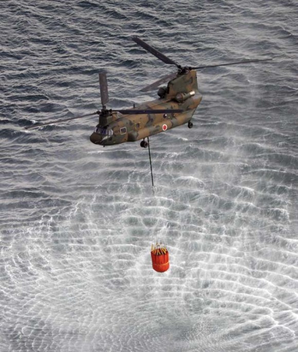 El Helicóptero de la Fuerza Aérea de Japón recoge agua de mar para verter sobre sobre el reactor de Fukushima. Foto: AFP