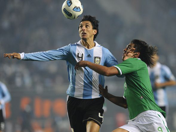 En la cabeza. Burdisso corre e intenta llevar el balón en el aire. Foto: AFP