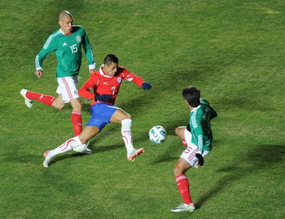 Alexis Sánchez (centro) maneja el balón entre los mexicanos Jorge Enríquez (izquierda) y el defensor Darvin Chávez. Foto: Ronaldo Schemidt/AFP/Getty Images