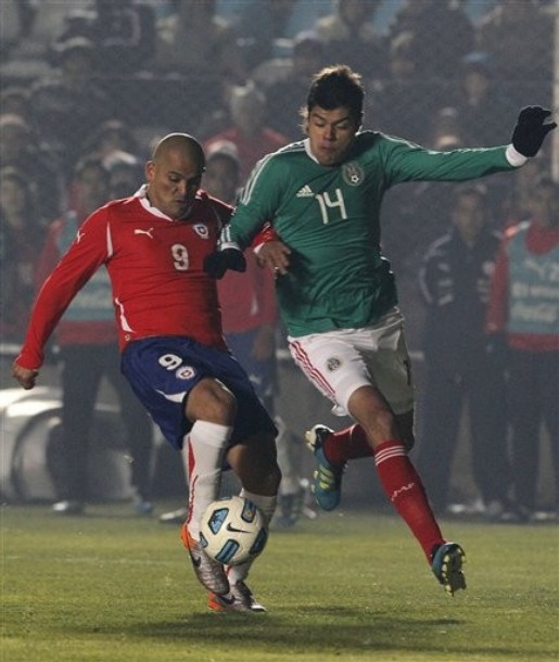 El chileno Humberto Suazo (derecha) y el mexicano Nestor Araujo luchan por el balón. Foto: Ricardo Mazalan/AP. 