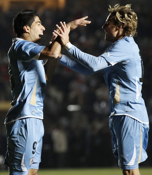 El uruguayo Luis Suárez (izquierda) celebra su gol contra Perú con su compañero de equipo Diego Forlán en el primer partido de la Copa America en San Juan, Argentina. Foto: REUTERS/Juan Medina. 