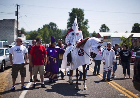 Miembros de tres órdenes del Ku Klux Klan (KKK) marchan por la ciudad de Dungannon con motivo de las celebraciones por el 4 de Julio, en el estado de Virginia (EE.UU.), el 2 de julio de 2011. El Imperio Invisible ha experimentado un resurgir en Virginia, con protestas y ceremonias en las que se prenden fuego cruces para manifestarse contra los derechos de los homosexuales, los cambios raciales en la población, y en contra de que Barack Obama, de raza negra, lidere el país. EFE/JIM LO SCALZO