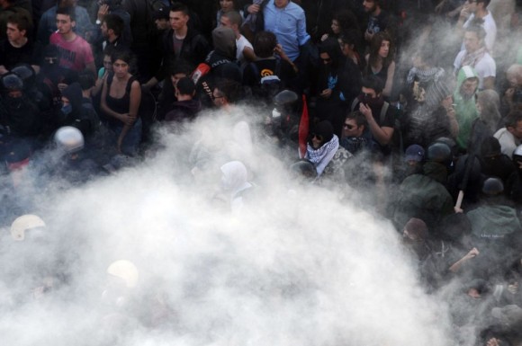 Manifestantes y policías italianos, entre una nube de humo en el centro de Roma. Foto: AFP
