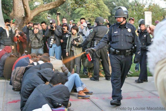 El policía John Pike durante una rociada con gas pimienta a los estudiantes de la Universidad de California-Davis.