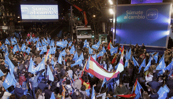 Los simpatizantes del PP comienzan las celebraciones frente a la sede de la calle Génova en Madrid.