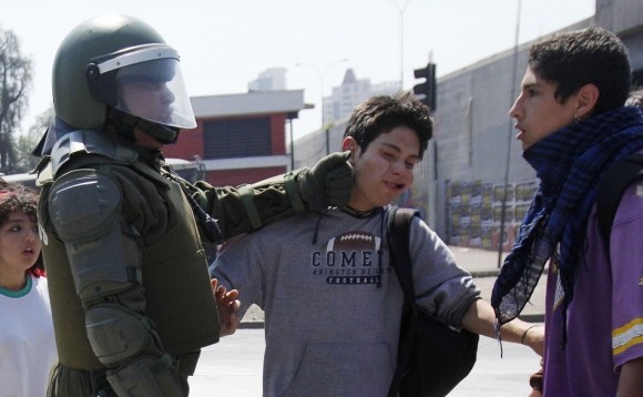 Un estudiante es golpeado en la cara por un policía en Chile. Los estudiantes de Chile exigen un nuevo marco para la educación. (Reuters / VICTOR RUIZ CABALLERO)