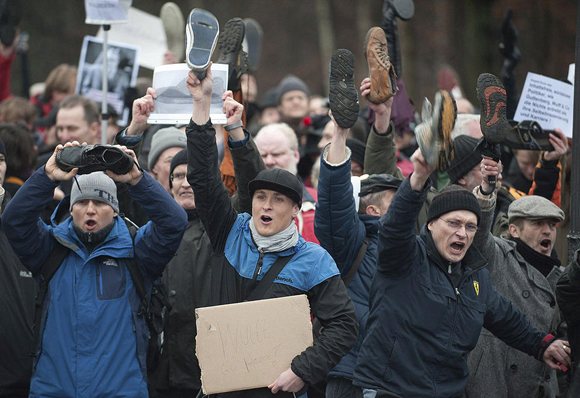 Cientos de personas se manifestaron este sábado en el palacio del presidente de Alemania, Christian Wulff, con sus zapatos en alto. Foto: EFE