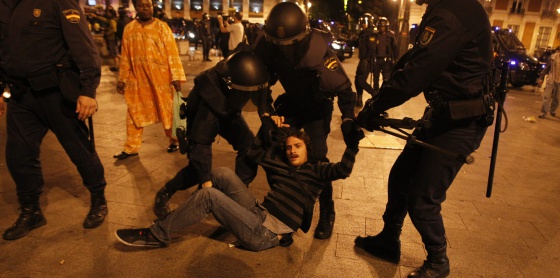 Un joven es desalojado de Sol por varios agentes. Foto: El País/ LUIS SEVILLANO