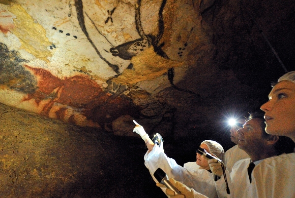 El presidente de Francia, Nicolas Sarkozy y su esposa Carla Bruni-Sarkozy observan las pinturas rupestres en su visita a las cuevas de Lascaux para el 70 aniversario de su descubrimiento en Montignac, Sur-Oeste de Francia, el 12 de septiembre de 2010. (Reuters / Philippe Wojazer)