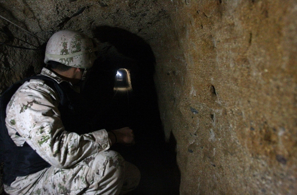 Un soldado mexicano se ve dentro de un túnel descubierto en Tijuana, el 25 de noviembre de 2010. Según medios locales, las autoridades encontraron un túnel de traficante de drogas que une la ciudad de la frontera norte de Tijuana con los Estados Unidos. El túnel estaba en pleno funcionamiento con un sistema de ventilación y electricidad, y los carriles para el transporte de narcóticos. (Reuters / Jorge Duenes)
