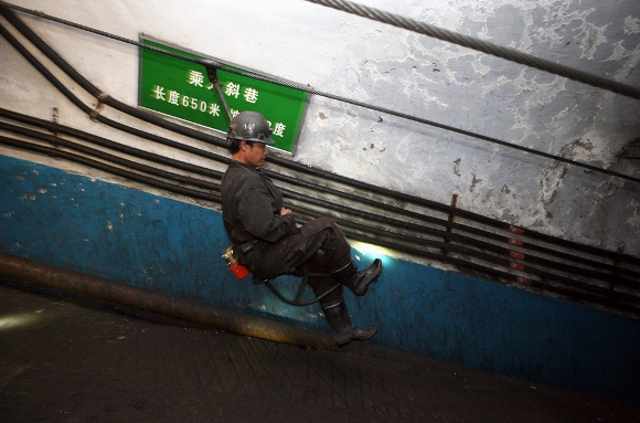 Un socorrista monta un ascensor por un túnel para reforzar las operaciones de rescate en la mina de carbón Pingyu No.4 en Yuzhou, provincia de Henan, 16 de octubre 2010. Una explosión en la mina de carbón china había matado a por lo menos 20 mineros en la provincia central de Henan, informó la prensa estatal. (Reuters / Stringer)
