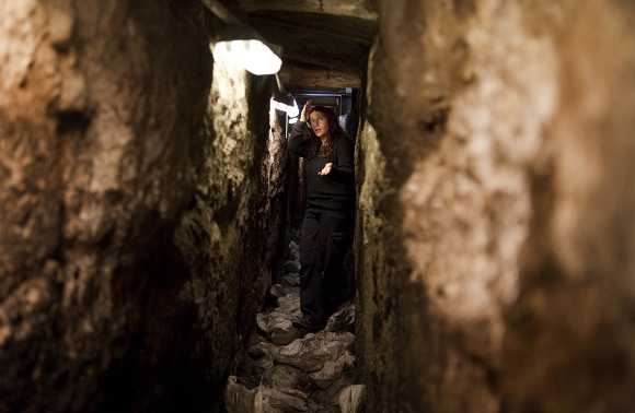 La arqueóloga Annete Nagar muestra el túnel de drenaje del Segundo Templo, de 2000 años de antigüedad, en la Ciudad Vieja de Jerusalén en el lado oeste del Muro de los Lamentos judío, el 25 de enero de 2011. Arqueólogos israelíes han terminado el trabajo, que comenzó en 2004, en el túnel que se inicia en un sitio cerca de la mezquita Al-Aqsa, punto de inflamación dentro de los muros de la Ciudad Vieja de Jerusalén, dijeron las autoridades. (Menahem Kahana / AFP / Getty Images)
