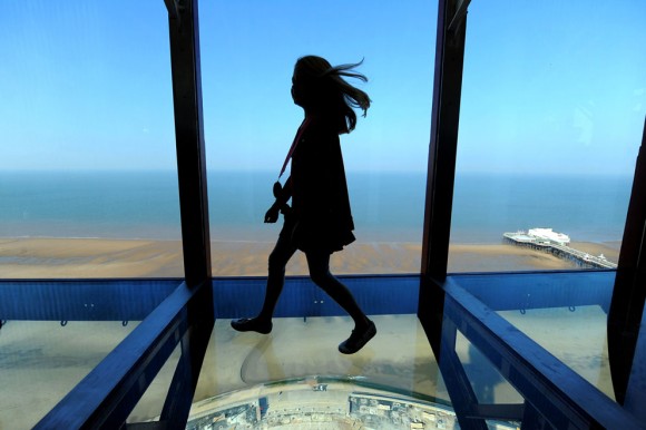 Amber Houghton, ganadora de un concurso, es una de las primeras personas en caminar sobre la nueva pasarela de vidrio en la cima de la torre de Blackpool en Blackpool, Inglaterra, el 1 de septiembre de 2011. Foto: Andrew Yates/AFP/Getty Images.
