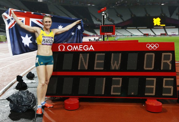  La australiana Sally Pearson posa junto al tablero electrÃnico de tiempos hoy, martes 7 de agosto de 2012, lugo de ganar la prueba femenina de los 100 metros vallas en los Juegos OlÃmpicos de 2012, en Londres (Reino Unido). EFE/KERIM OKTEN