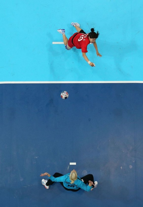 La surcoreana Jihae Jung lanza un penalti a la danesa Christina Pedersen durante el partido de la fase preliminar del Grupo B de balonmano. Foto: RICHARD HEATHCOTE (GETTY IMAGES)