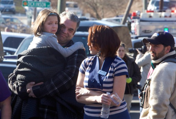   Un padre lleva a su hija tras el tiroteo en la escuela Sandy Hokk de Connecticut. Foto: Reuters.