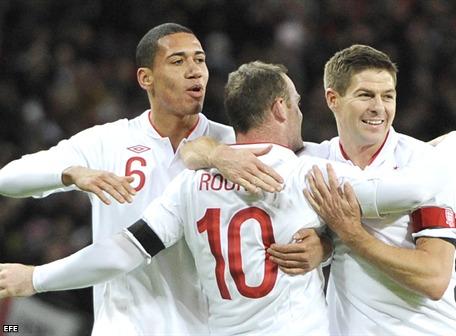Momentos en que el inglés Wayne Rooney (c) celebra con sus compañeros Chris Smalling (i) y Steven Gerrard (d) después de anotar un gol ante Brasil, durante un partido amistoso en el estadio Wembley. 