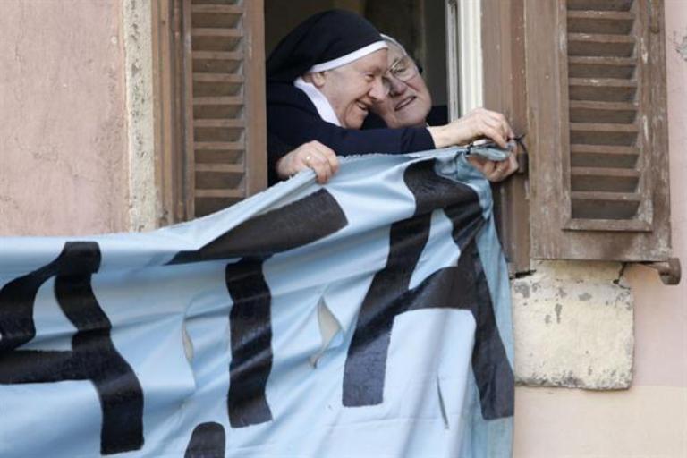 Monjas emocionadas cuelgan un cartel para que el Papa lo vea. Foto AP