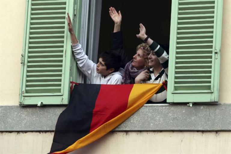 Unos fieles logran acaparar la atención del alemán Ratzinger con una bandera de su país frente a la ventana de Castelgandolfo. Foto AP