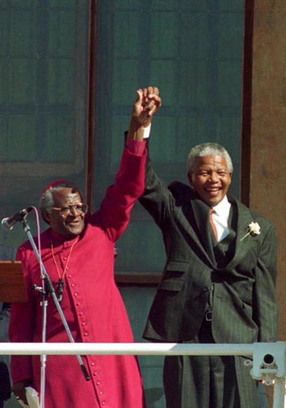 Nelson Mandela  y Desmond Tutu alzan sus manos tras la victoria en las elecciones de 1994 del Congreso Nacional Africano (CNA).