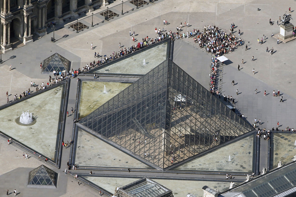 An aerial view shows people waiting outside the Pyramid of the Louvre Museum in central Paris