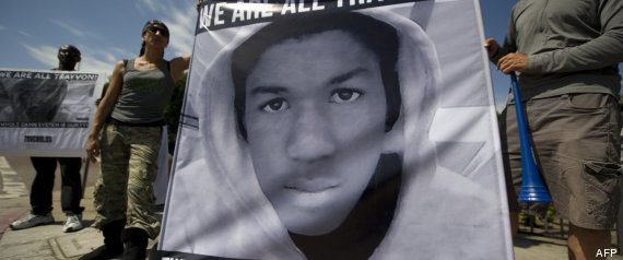 Dos manifestantes sujetan una pancarta con el rostro de Trayvon Martin en Los Ángeles. Foto: AFP.