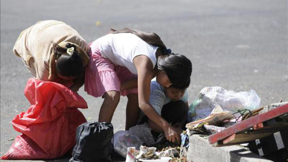 Niños guatemaltecos buscan alimentos entre la basura.