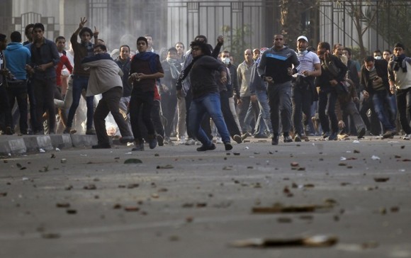 Anti-government protesters and members of the Muslim Brotherhood throw stones and glasses during clashes with supporters of Egypt's army and police at Ramsis street, which leads to Tahrir Square in downtown Cairo