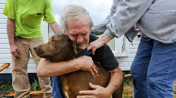 Greg Cook encuentra a su perro Coco dentro de su casa en Alabama después del tornado en Marzo de 2012