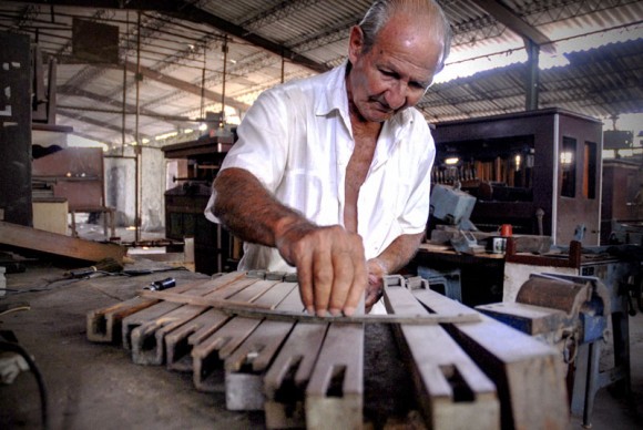 Francisco Cuayo, proveniente de una familia precursora de la tradición de órganos musicales y fundador del taller, da mantenimiento a una escala de acompañamiento en la Fábrica de Instrumentos Musicales y Órganos Neumáticos, única de su tipo en Cuba, ubicada en la oriental ciudad de Holguín. FOTO/Juan Pablo Carreras