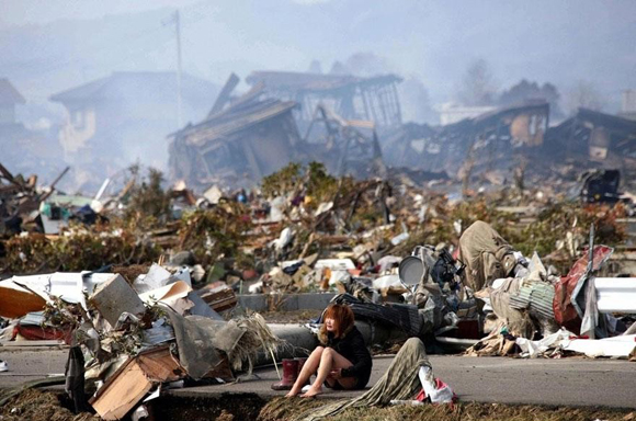 Una mujer sentada, se horroriza de la destrucción causada en Natori, Japón, por un terremoto seguido de un tsunami, en 2011