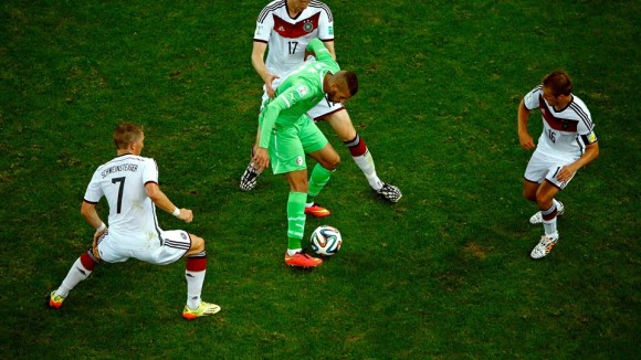 Islam Slimani of Algeria controls the ball against Bastian Schweinsteiger (L), Per Mertesacker (C) and Philipp Lahm of Germany