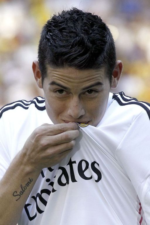 James Rodríguez besa el escudo del Real Madrid durante su presentación. FOTO EFE.