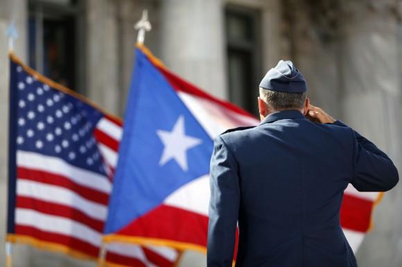 Un miembro de la Guardia de Honor del Ejército de EE.UU. rinde homenaje a las banderas de Puerto Rico y Estados Unidos.