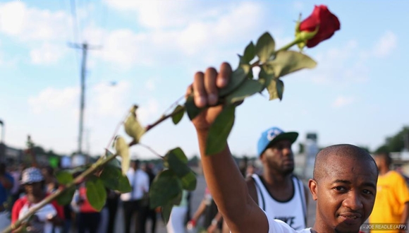 Un manifestante sostiene una rosa durante la marcha en Ferguson para pedir justicia por la muerte de Michael Brown. 
