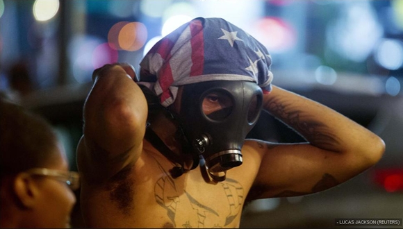Un manifestante con la cara cubierta por una máscara de gas durante los disturbios que se saldaron con 31 detenidos.
