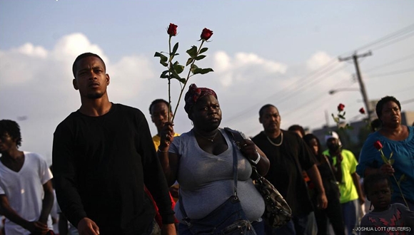 Manifestantes con rosas piden justicia por John Brown, que falleció tras recibir seis disparos de un agente.
