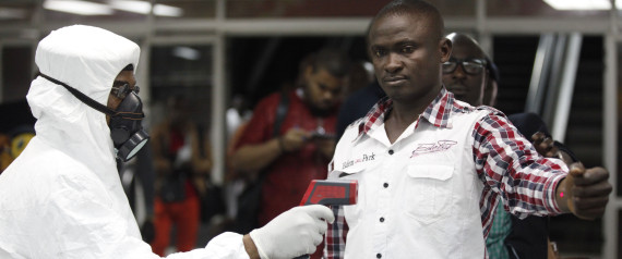 A Nigerian port health official uses a thermometer on a worker at the arrivals hall of Murtala Muhammed International Airport in Lagos, Nigeria,  Wednesday, Aug. 6, 2014. A Nigerian nurse who treated a man with Ebola is now dead and five others are sick with one of the world's most virulent diseases, authorities said Wednesday as the death toll rose to at least 932 people in four West African countries. (AP Photo/Sunday Alamba)
