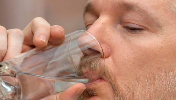 WikiLeaks founder Julian Assange has a drink of water during a news conference at the Ecuadorian embassy in central London August 18, 2014. Assange, who has spent over two years inside Ecuador's London embassy to avoid extradition to Sweden, said on Monday he planned to leave the building "soon", without giving further details. REUTERS/John Stillwell/pool (BRITAIN - Tags: POLITICS CRIME LAW)