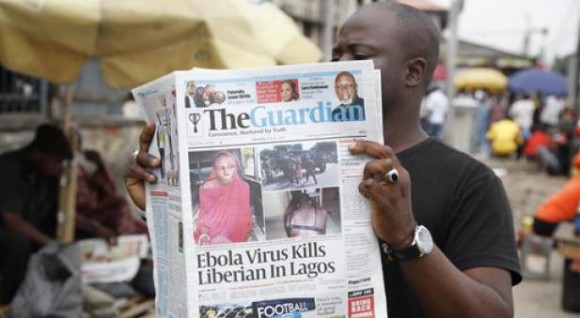 Un hombre lee un periódico en una calle de Lagos, Nigeria, en el que se reportan las muertes causadas por el ébola en diferentes naciones del oeste de África. Foto: AP.
