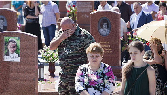 Familiares de las víctimas de Beslán, en el cementerio. Imagen de 2013. Foto: EFE. 